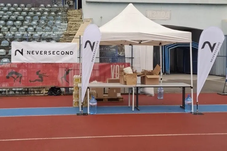 Neversecond tent and flags on the running track at the Danube 24h Run city stadium in Ruse
